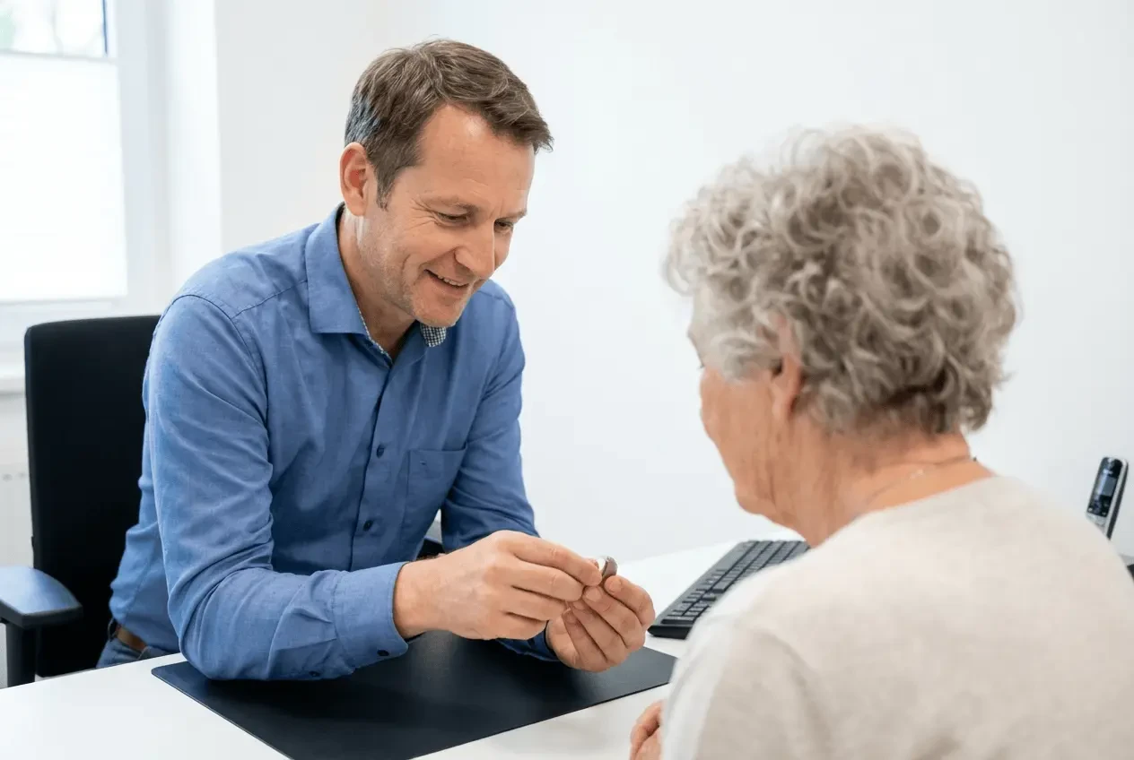 Master hearing acoustician conducting professional hearing test with patient in specialist store using audiometer